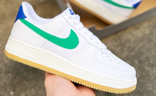 Person Holding Nike Air Force 1 07 Shoes