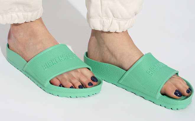 Woman is Wearing Birkenstock Unisex Barbados EVA Sandals in Bold Jade Color