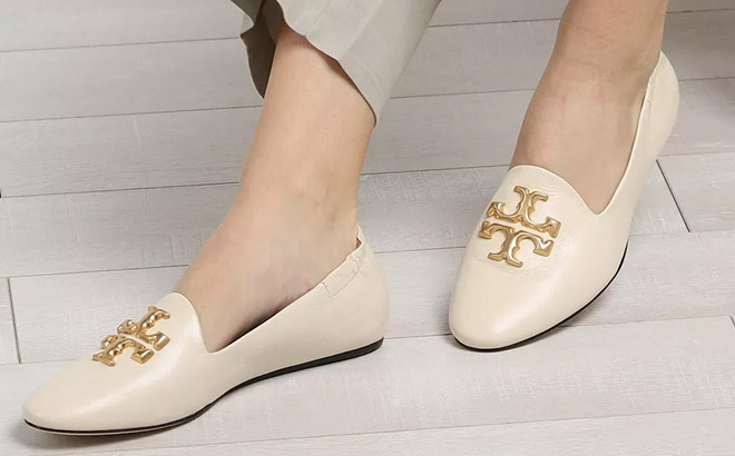 Woman is Wearing Tory Burch Eleanor Logo Leather Loafers in New Cream Color