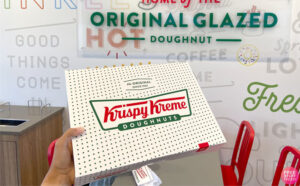 a Hand Holding a Box of Krispy Kreme Doughnuts