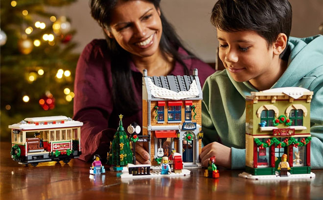 A Mother and a Kid Playing with a LEGO Holiday Main Street Building Set