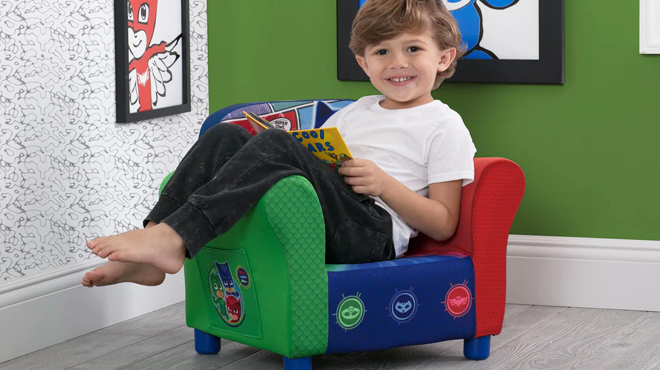 A Boy Sitting on PJ Masks Delta Children Upholstered Chair