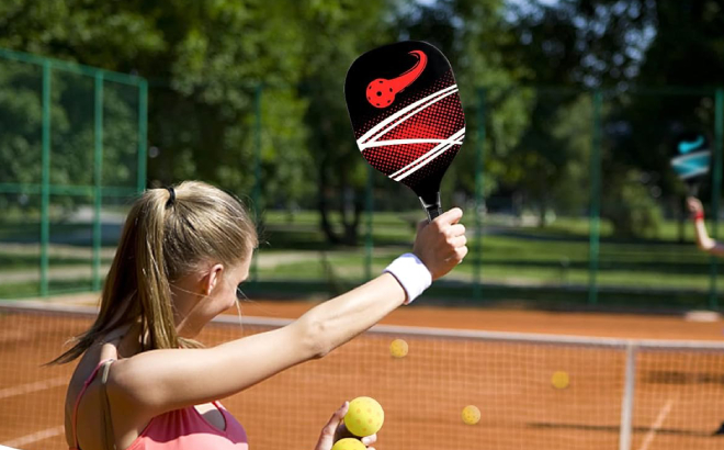 A Lady Holding a Pickeball and a Paddle