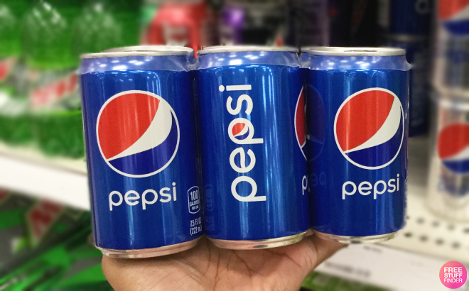 Hand Holding Pepsi Mini Soda Cans