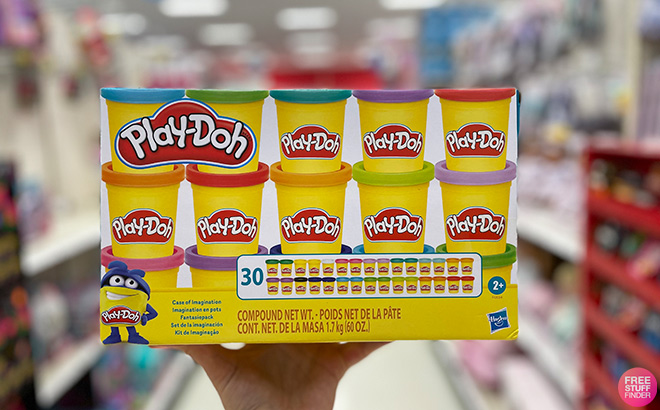 Hand Holding Play Doh Case of Imagination in a Store Aisle