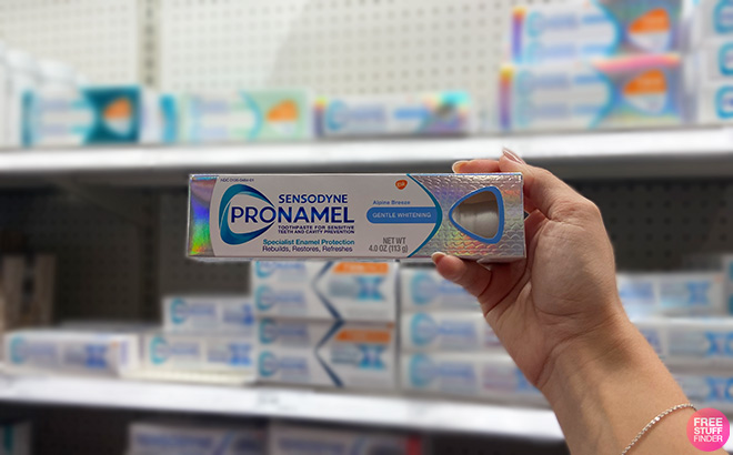 Hand Holding Sensodyne Pronamel Toothpaste in a Store Aisle