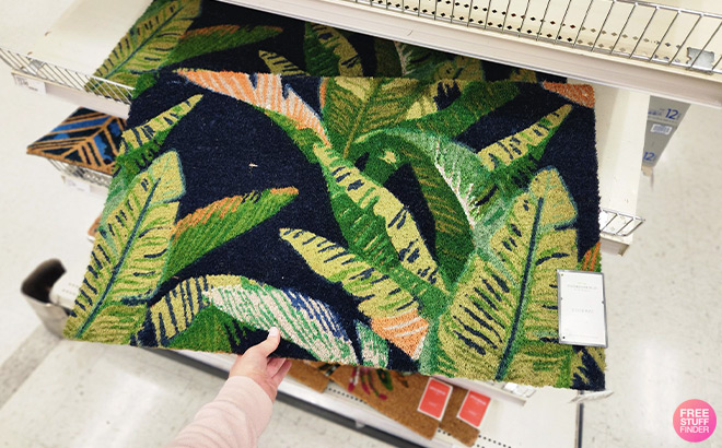 Hand Pulling a Doormat of Store Shelf