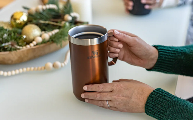 Hands Holding Stanley 24 Ounce Stay Hot Camp Mug