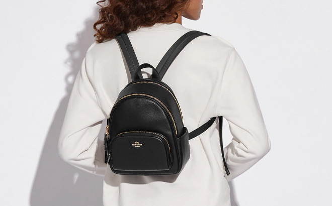 Woman is Wearing Coach Mini Court Backpack in Black and Gold Color