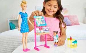 A Child Playing with the Barbie Teacher Doll Set