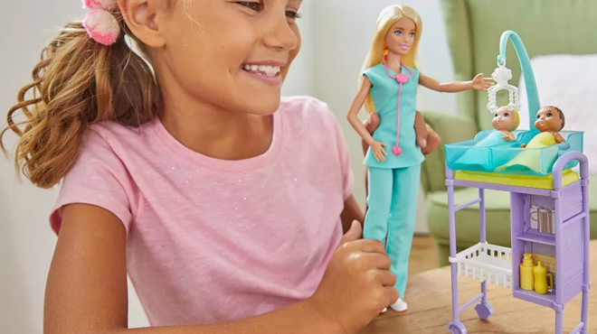 A Girl Playing with Barbie Baby Doctor Blonde Doll and Playset