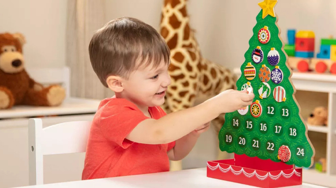 A Person playing with Melissa Doug Countdown to Christmas Wooden Advent Calendar