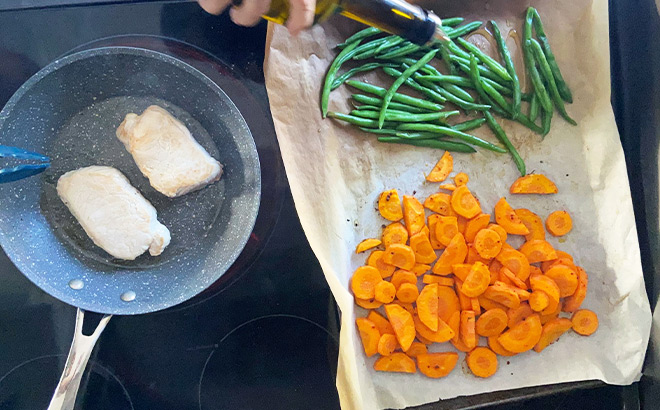 Chicken Cooking on a Pan next to Vegetables