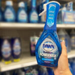 Hand Holding Dawn Fresh Scent Platinum Powerwash Dishwashing Liquid Dish Soap Spray in a Store Aisle