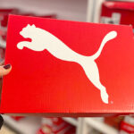 Hand Holding Puma Shoe Box in a Store