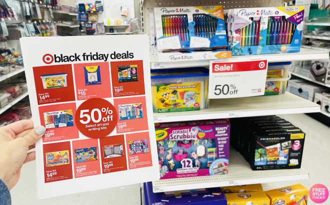 Hand Holding a Target Black Friday Ad with Overview of Crayola Products in the Background