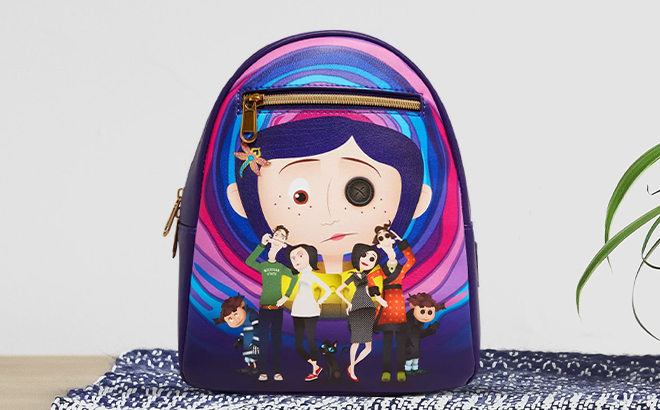 Loungefly Coraline Normal Other World Group Mini Backpack on table