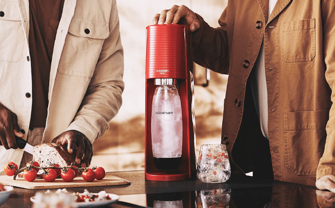 Man is Using SodaStream Terra Sparkling Water Maker Bundle in Red Color