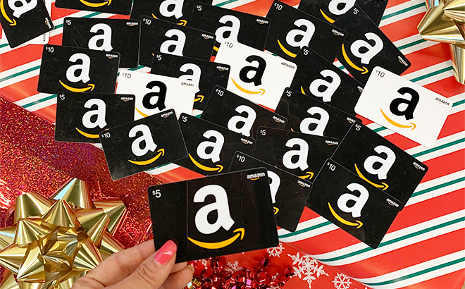 Tina Holding Amazon Gift Card with Many More Amazon Gift Cards in the Background