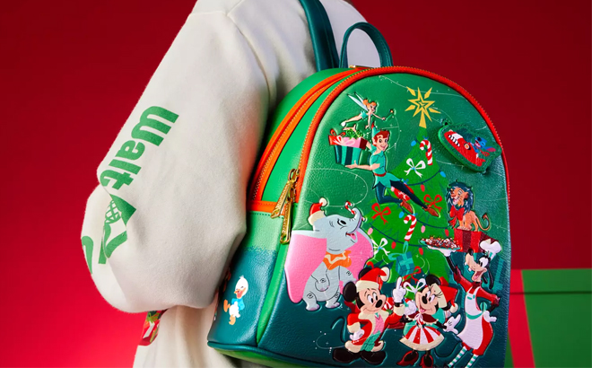 Woman Wearing a Disney Classics Christmas Glow in the Dark Loungefly Mini Backpack