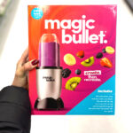 Woman holding a Magic Bullet Personal Blender in a box