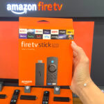 Woman holding an Amazon Fire TV Stick Lite