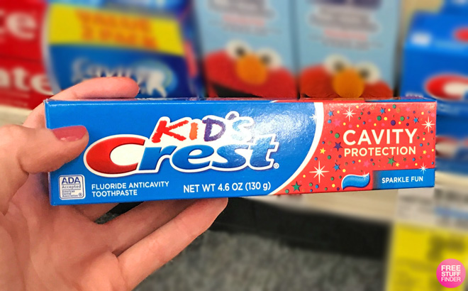 A Hand Holding a Crest Kids Toothpaste