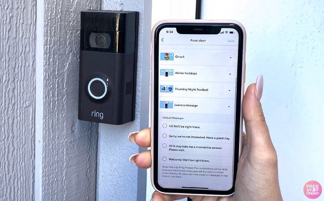 A Person Holding a Phone with Grinch Info and a Ring Doorbell on the Wall