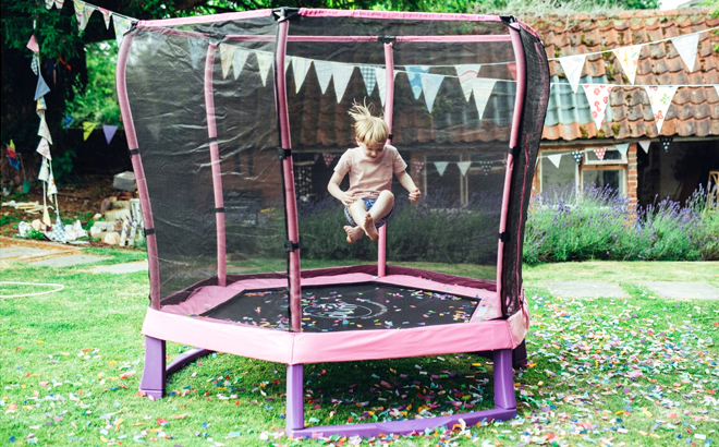 Boy Jumping in the Plum Play 7 Foot Trampoline with Safety Enclosure