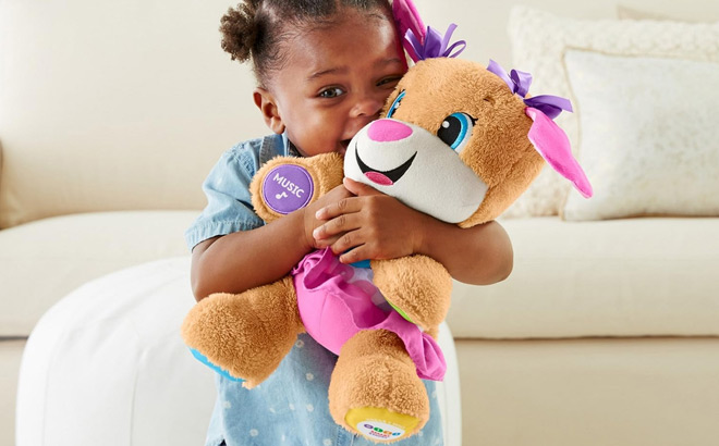 Child hugging a Fisher Price Laugh Learn Plush Dog