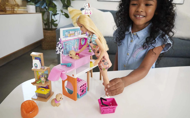 Girl is Playing with Barbie Doll and Pet Boutique Playset