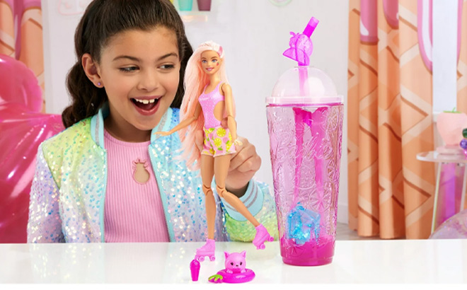 Girl is Playing with Barbie Pop Reveal Fruit Series Strawberry Lemonade Doll