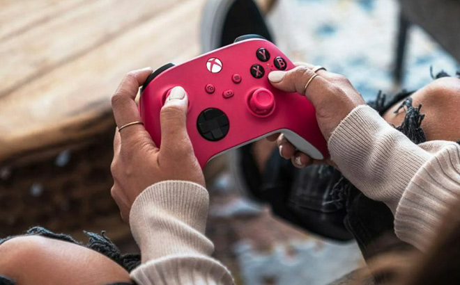 Hand Holding Microsoft Xbox Wireless Controller in Deep Pink Color