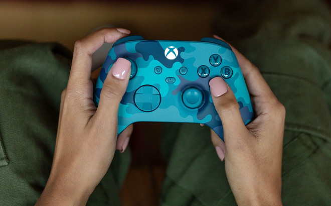 Hand Holding Microsoft Xbox Wireless Controller in Mineral Camo Color