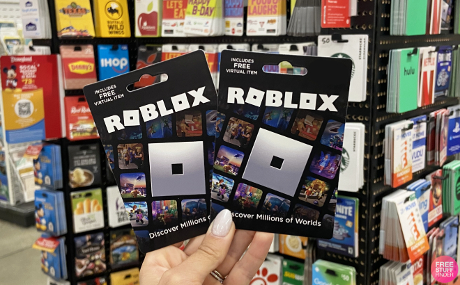 Roblox gift card in a hand over gift cards background. Stock Photo