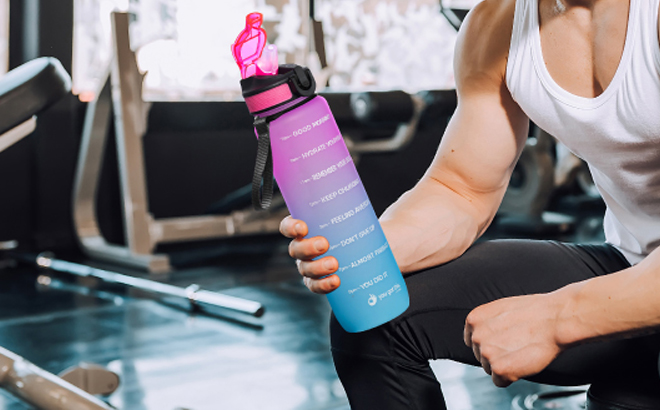 Man Holding a Motivational Sports 32 oz Water Bottle with Time Marker