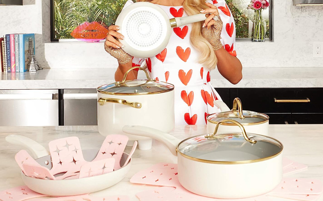 https://www.freestufffinder.com/wp-content/uploads/2023/12/Paris-Hilton-Holding-a-Pot-from-Her-Epic-Nonstick12-Piece-Cookware-Set-in-Cream-Color.jpg