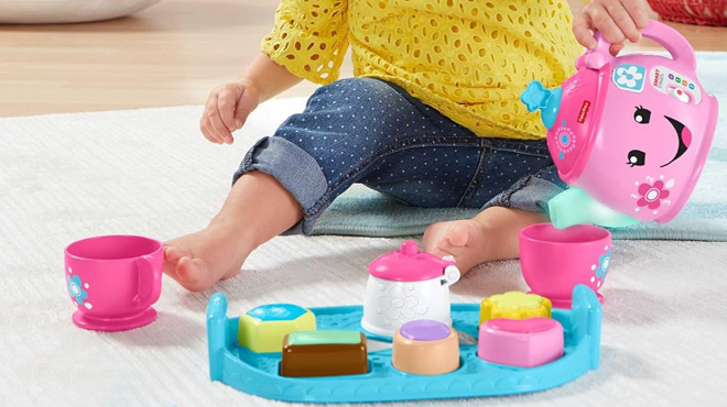 Toddler Playing with the Fisher Price Sweet Manners Tea Toy Set With Music and Lights