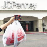 Woman Holding a Coupon in front of JCPenney Store