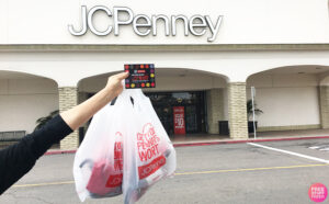 Woman Holding a Coupon in front of JCPenney Store