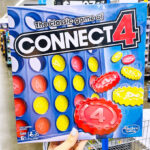 a Hand Holding Hasbro Gaming Connect 4 Game