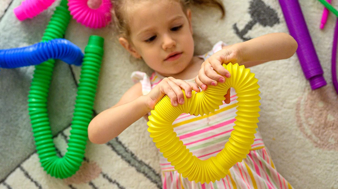 A Girl Shaping the Nutty Toys Pop Tubes Sensory Toys as Heart