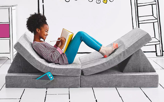 A Girl on a Covertible Play Couch in Gray Color