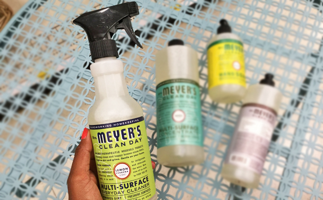 A Hand Holding a Mrs Meyers Clean Day All Purpose Cleaner Spary in Lemon Verbena Scent