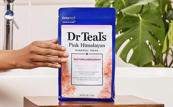 A Hand Holding a Pack of Dr Teals Pink Himalayan Mineral Soak