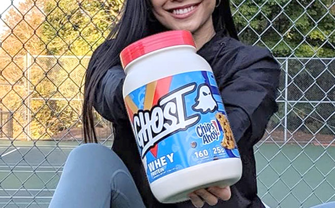 A Person Holding Ghost Whey Protein Powder