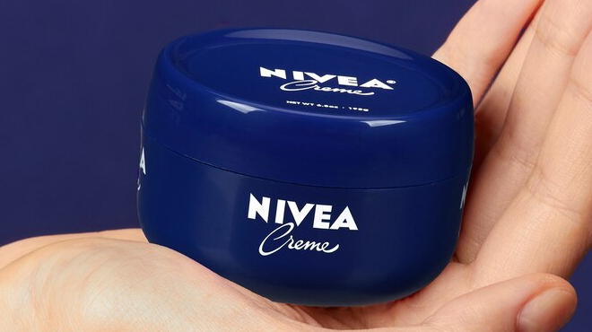 A person holding a Nivea Body Creme