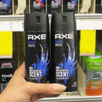 A person holding two bottles of Axe Phoenix Mens Body Spray