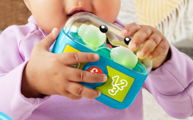 Baby Holding Fisher Price Pretend Earbuds