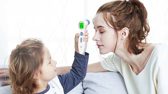 Child Holding a Forehead Thermometer